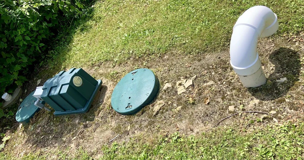 Tampas e respiro de uma mini estação de tratamento de esgoto enterrada no gramado