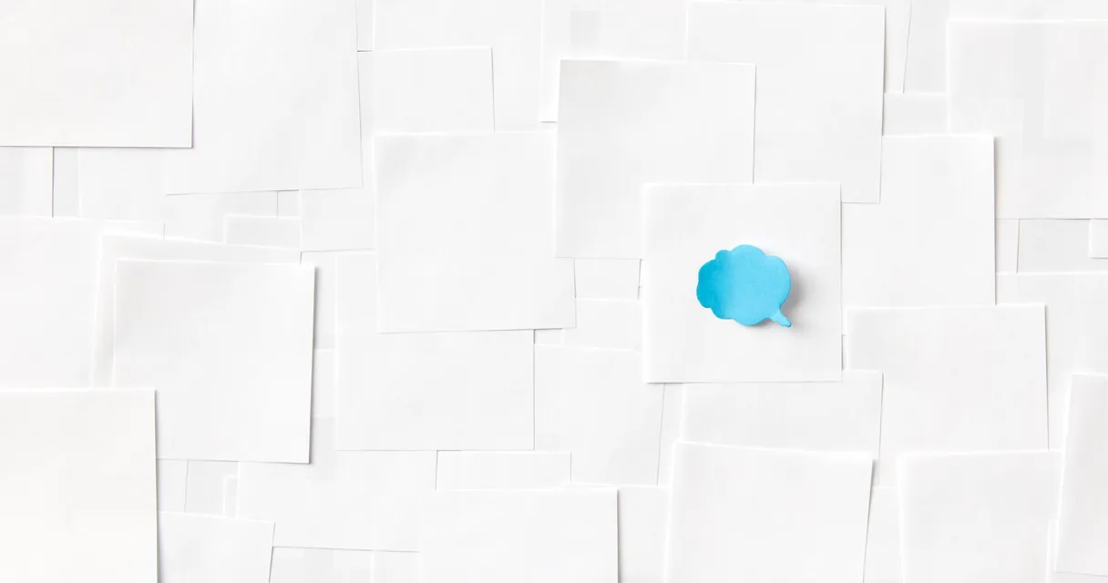 Balão azul de mensagem de papel sobre uma superfície branca, ilustrando a oferta de IPTV por mensagem