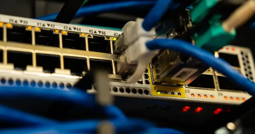 Cabos de rede ligados a um switch, parte da conferência da rede em um teste IPTV com 4K