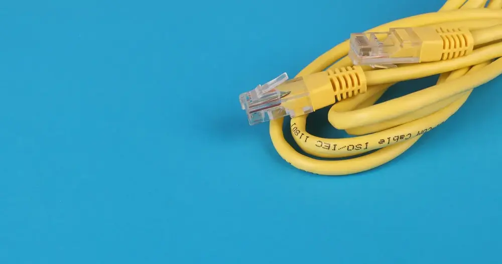 Cabo de rede amarelo sobre fundo azul, usado para conectar a TV Box no teste IPTV na TV Box